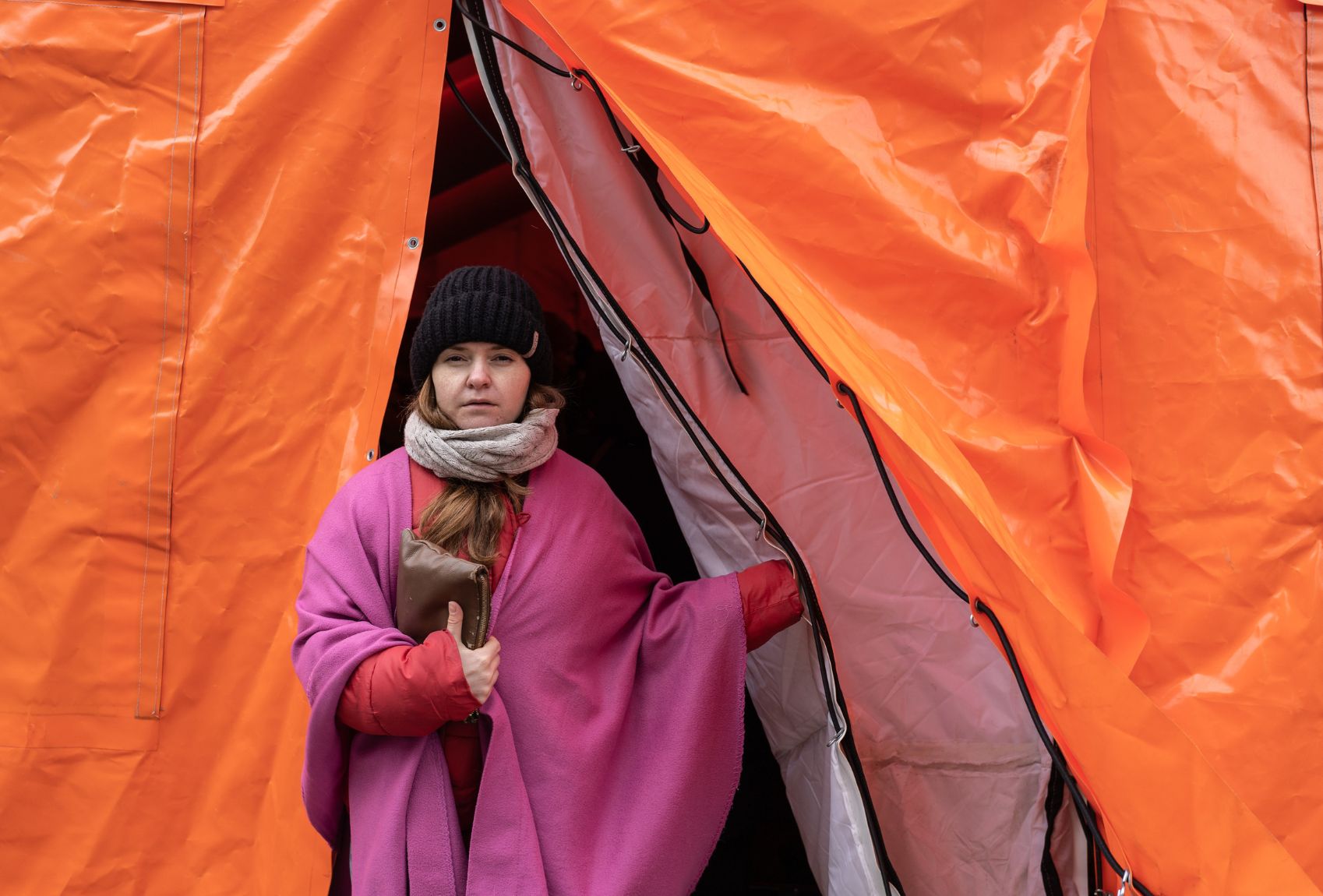 Frau verlässt ein orangenes Nothilfezelt.