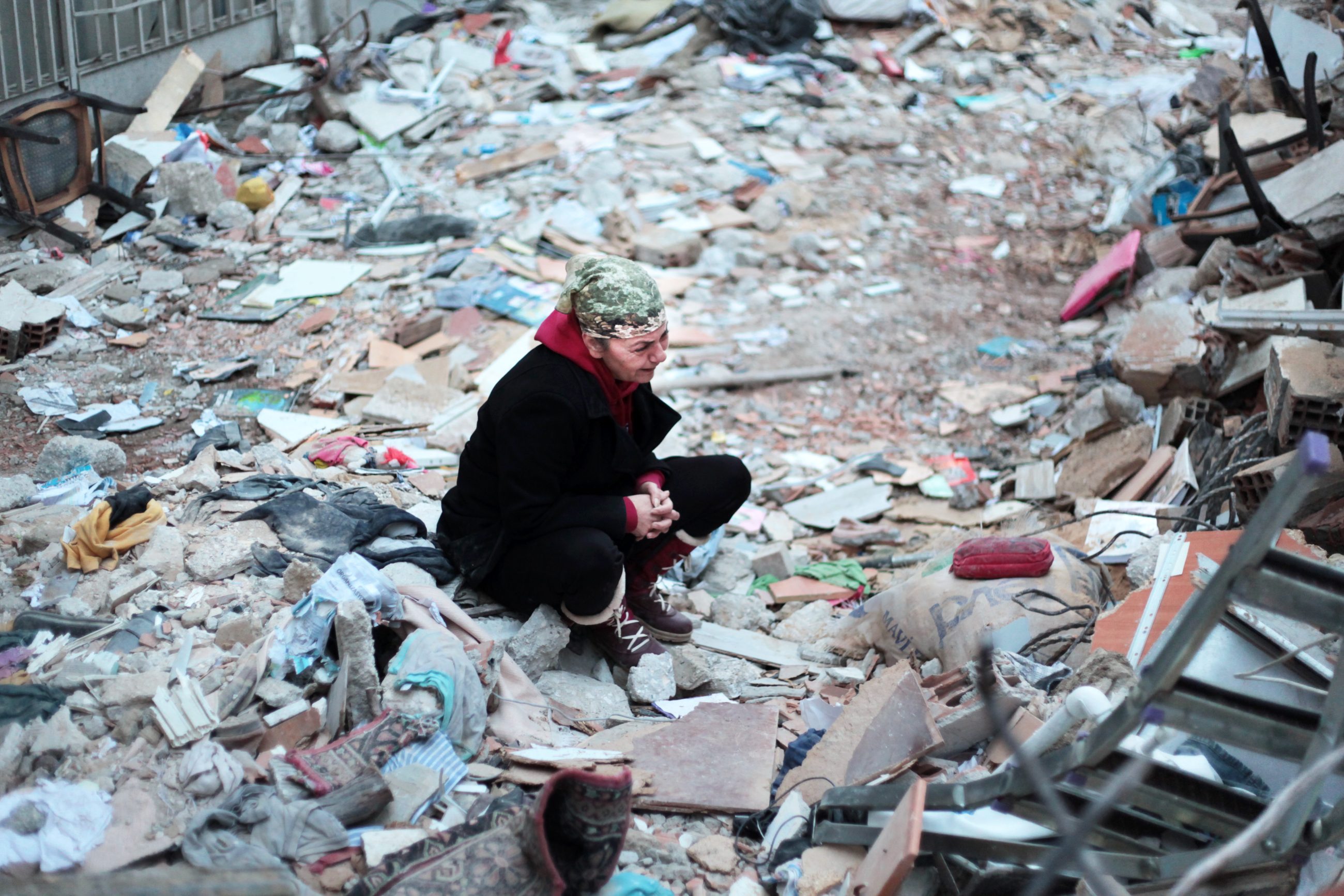 Frau schaut verzweifelt zu den Trümmern eines Wohnhauses. Credit: UN Women Özge Ergin