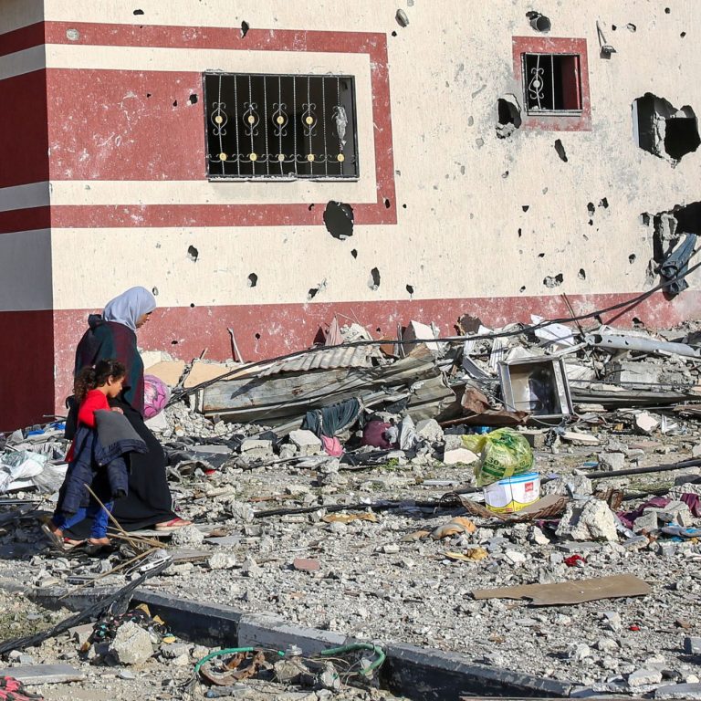 Frau läuft mit Tochter in den vom Krieg zerstörten Straßen - Feministischer Muttertag 2024