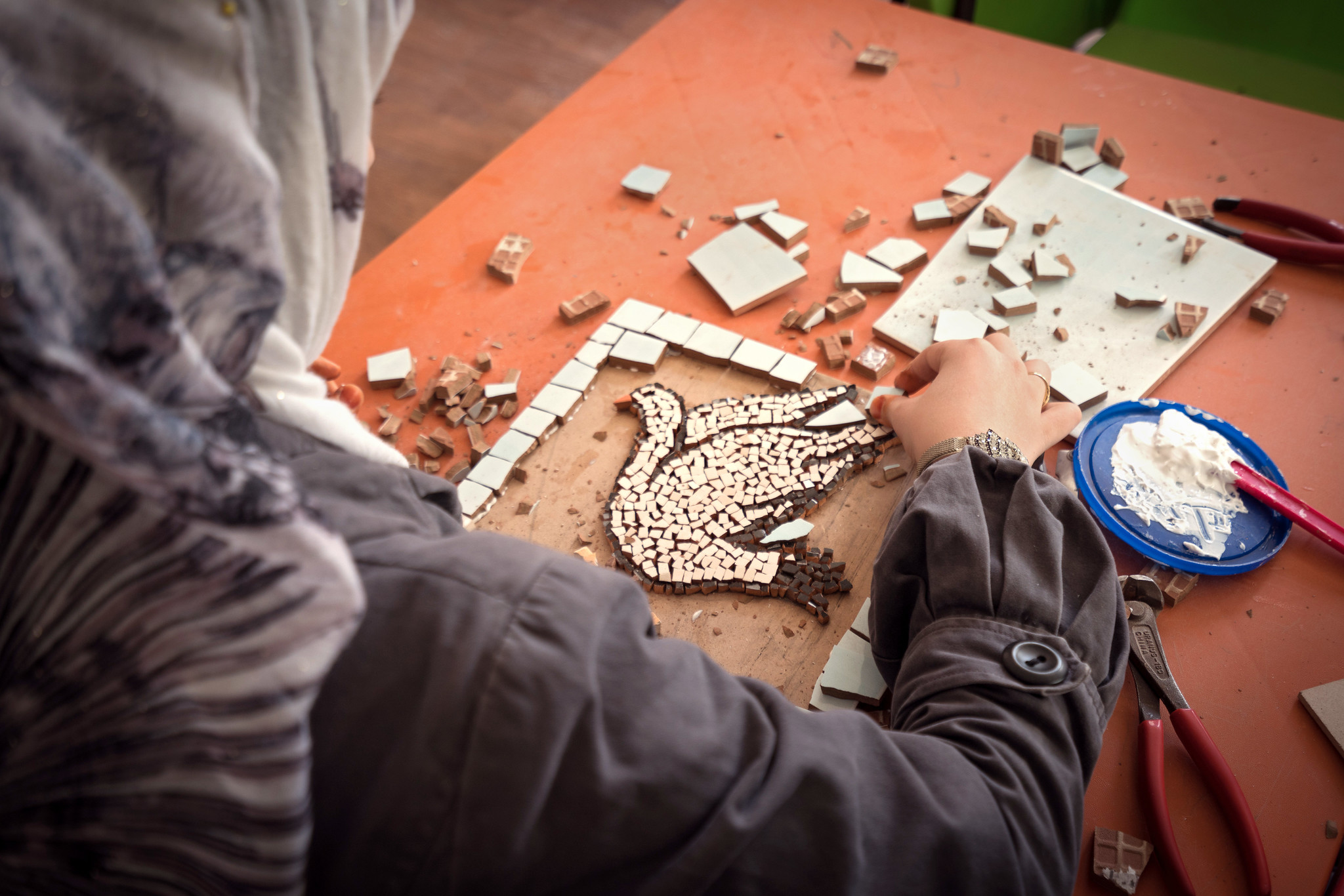 Frau erstellt Mosaik mit einer Taube