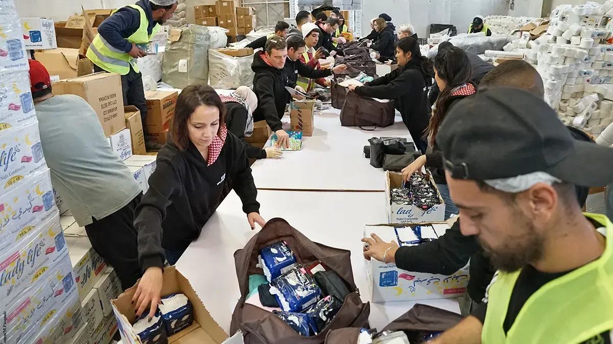 UN Women-Mitarbeiter*innen packen im Februar 2024 gemeinsam mit der Jordan Hashemite Charity Organization Hilfspakete mit Hygieneartikeln für Frauen und Mädchen in Gaza.