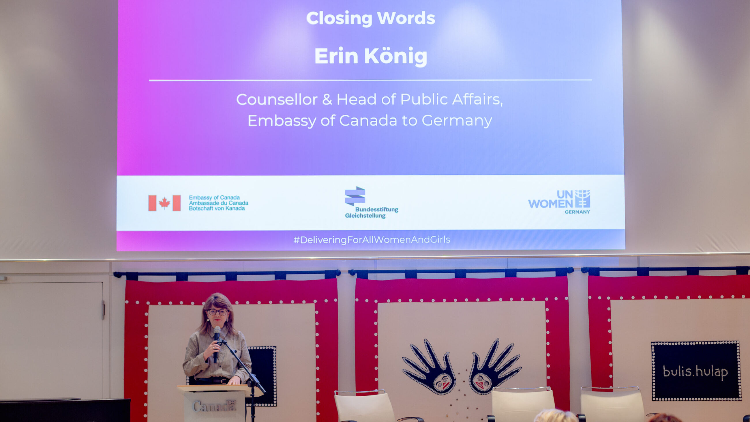 Erin König on stage at the international conference presenting her closing remarks.