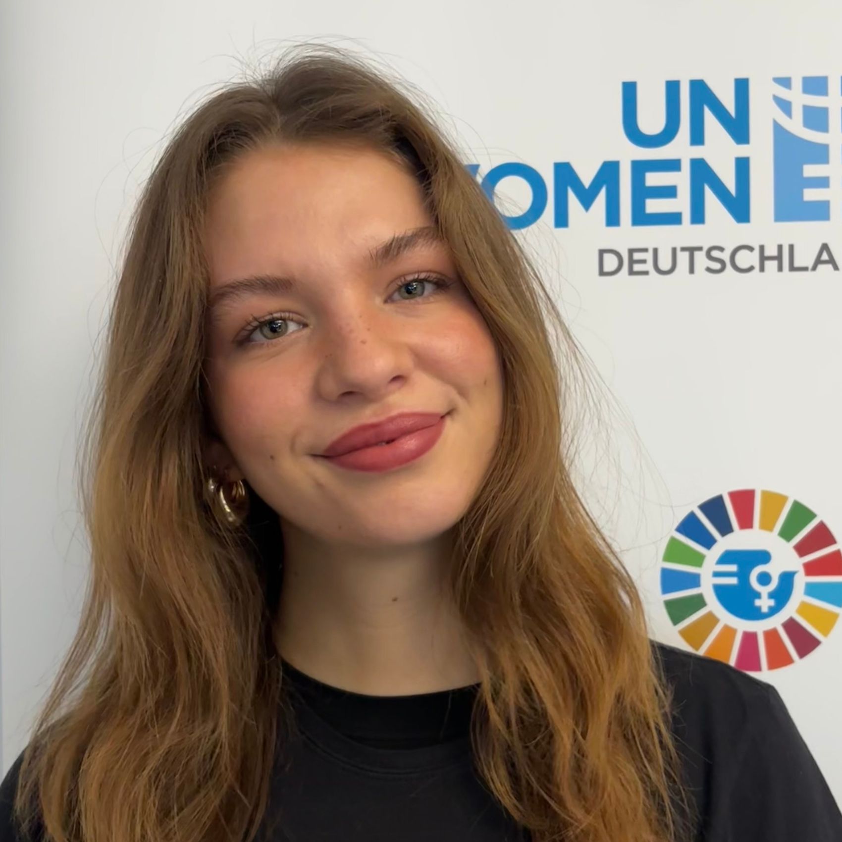Portrait von Alicia Fischer vor UN Women Deutschland Hintergrund