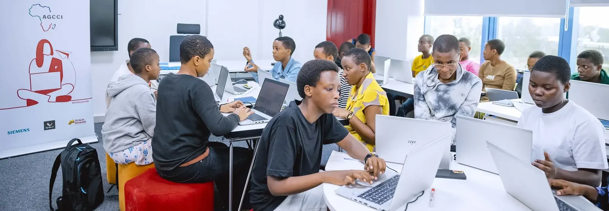 Mädchen an Tischen mit Laptops - African Girls Can Code Initiative (AGCCI)