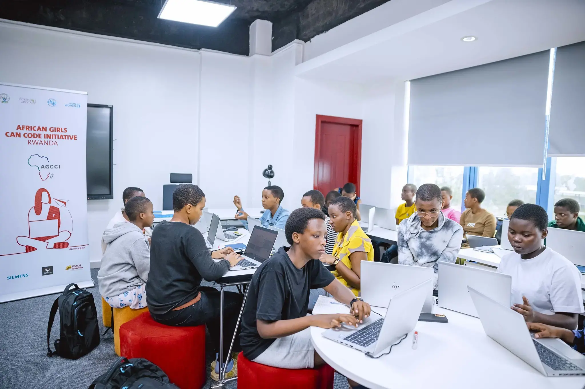 Mädchen an Tischen mit Laptops - African Girls Can Code Initiative (AGCCI)