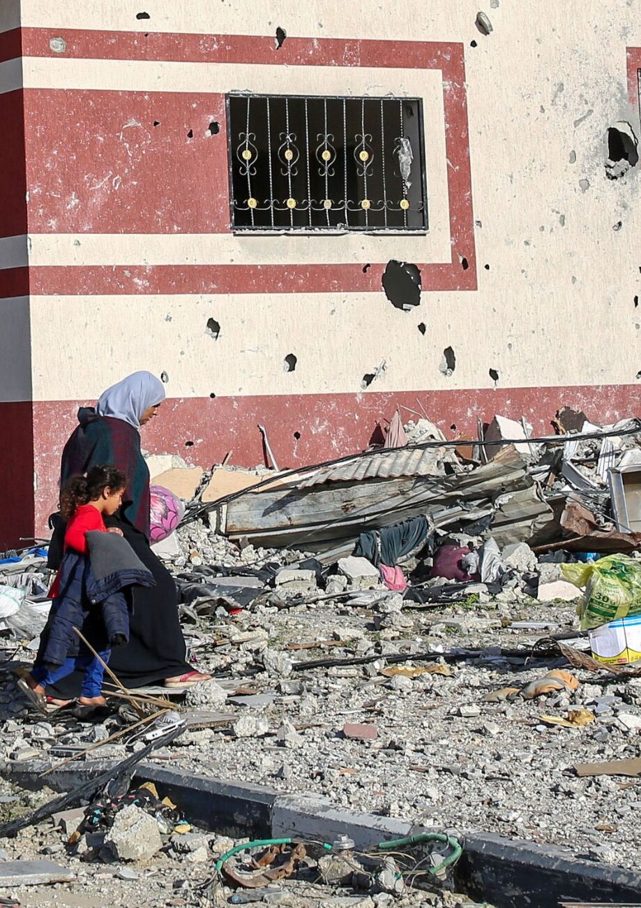 Frau läuft mit Tochter in den vom Krieg zerstörten Straßen - Feministischer Muttertag 2024