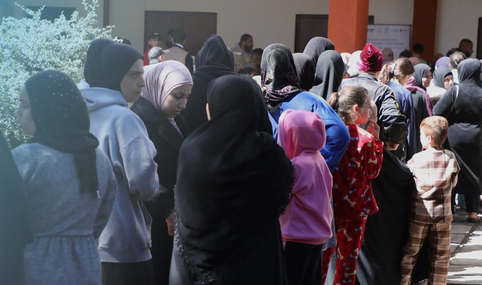 Frauen und Kinder stehen vor einer Einrichtung für Geflüchtete in einer Schlange - UN Women Nothilfe im Libanon
