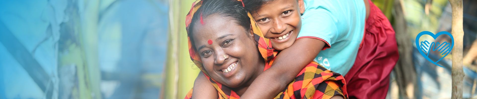 Sohn umarmt seine Mutter und beide lächeln in die Kamera - Bangladesch UN Women